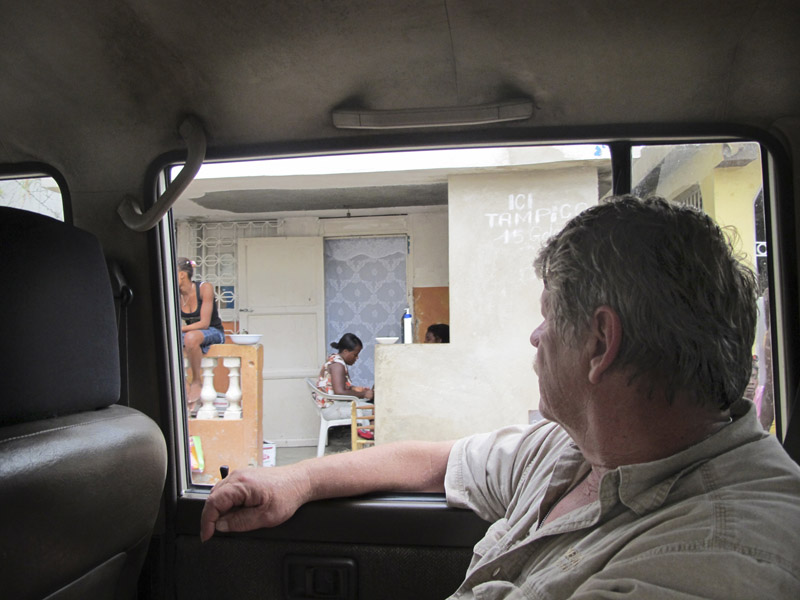Sea Hunter owner Greg Brooks rides Monday morning through the Haitian port of Miragoane in search of permission to offload the relief ship’s 10 containers and other large cargo. Above, the Maine relief ship sits at anchor.