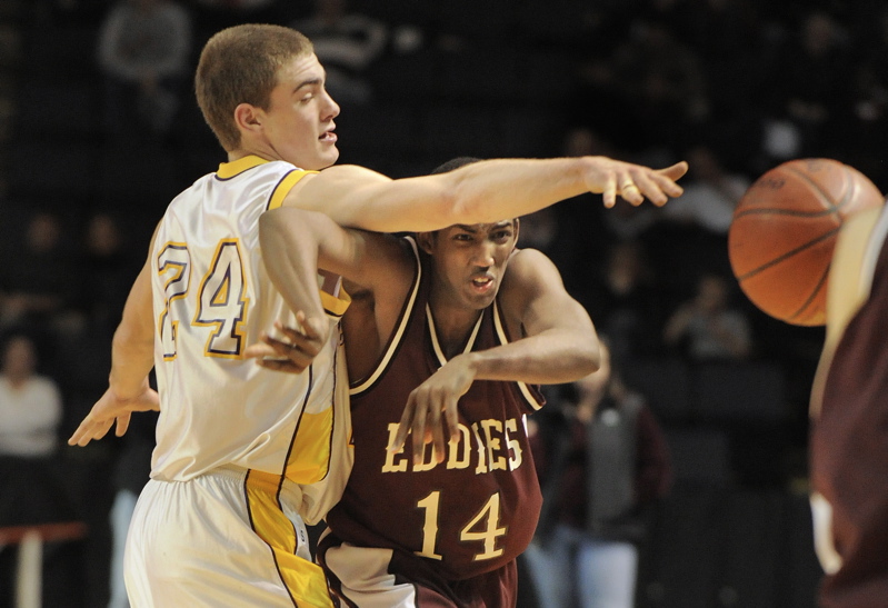 Peter Gwilym, left, of Cheverus attempts to knock a pass away from Yusef Iman of Edward Little during their Class A final Saturday night. Cheverus won, 55-50.