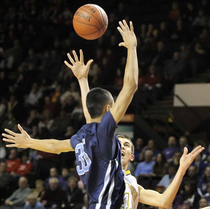 Louie DiStasio, rear, of Cheverus gets off a shot against Westbrook's Jose Nouchanthavong.