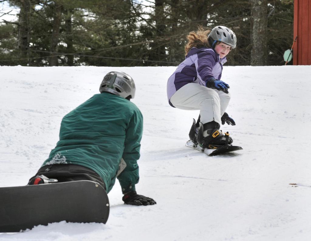 Deidre, 11, snowboards past dad Drew.