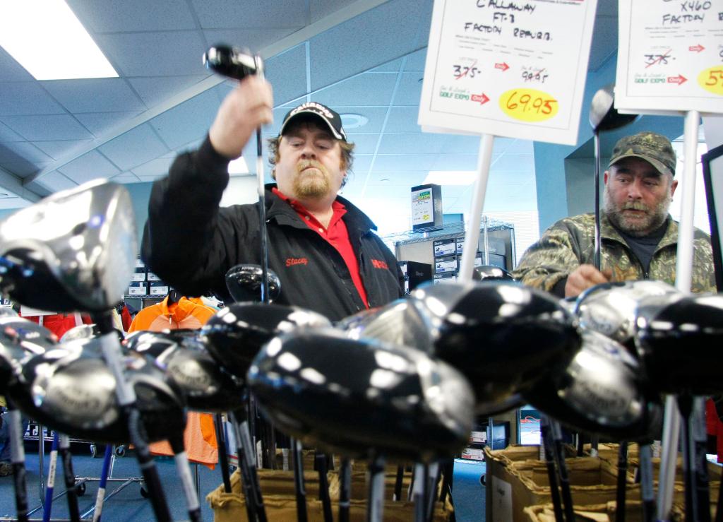 Stacey Edgerly of Cornish looks through discounted drivers for sale accompanied by his brother Danny at Sunday’s golf expo.