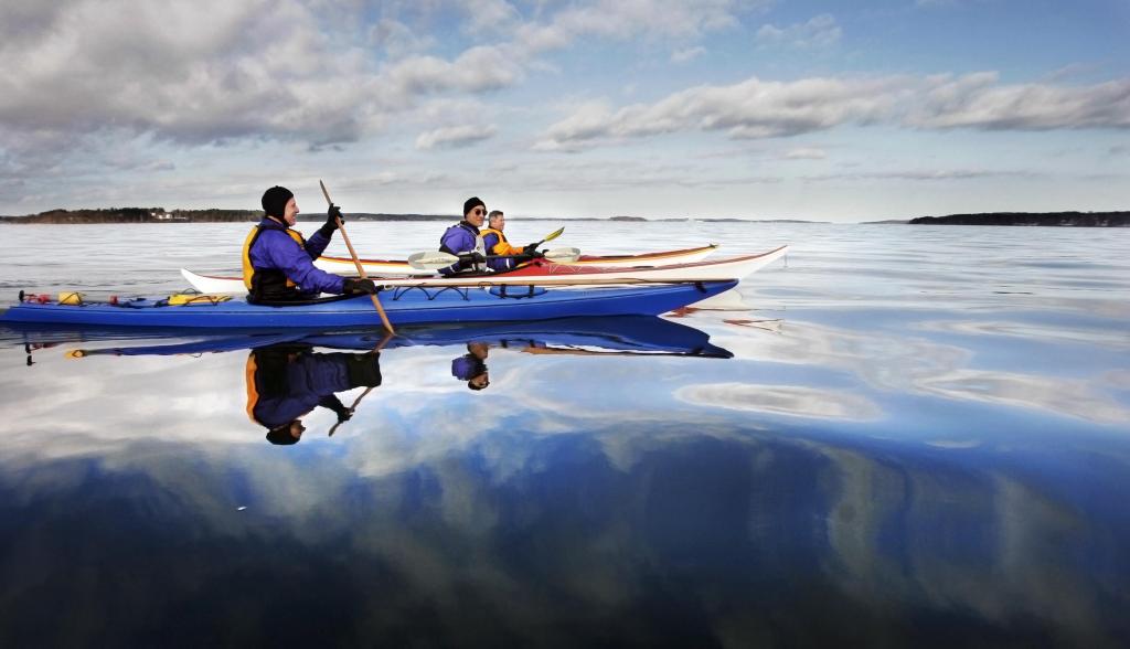 Kayakers paddle Casco Bay on a winter day. Winter kayaking requires particular attention to staying as warm and dry as possible.