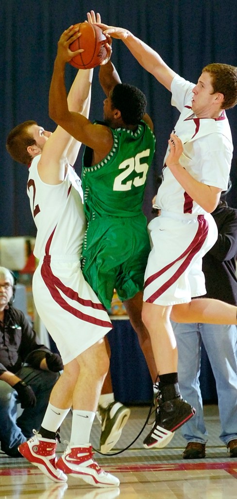 Jared Waite tries to get off a shot against Richmond's Kyle O'Brien, left, and Bruce Carver.