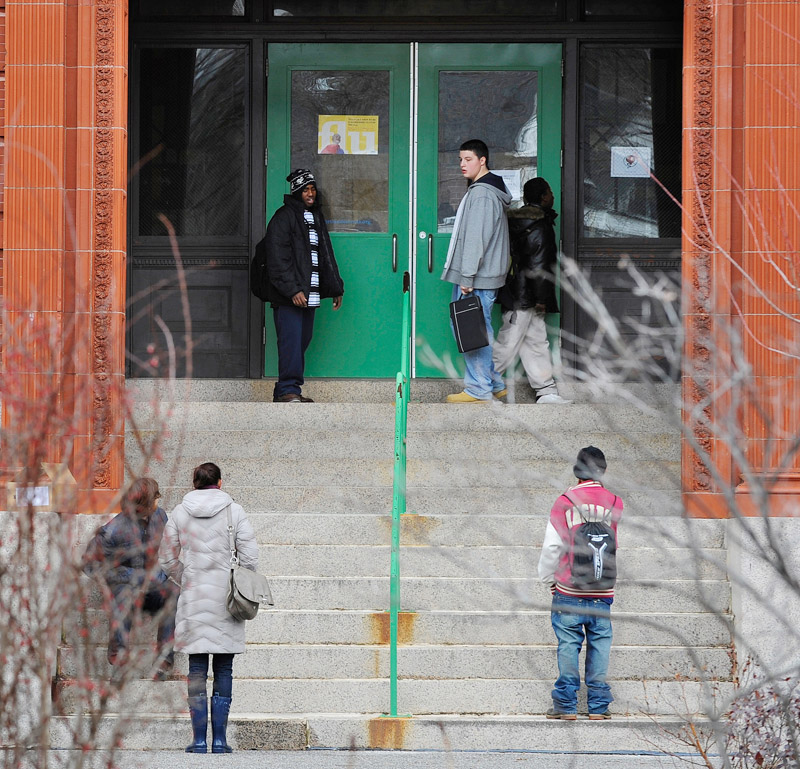 Teachers and students wait outside Lincoln Middle School during a lockdown after a threatening note was discovered this morning. The doors were opened soon after this photo was taken.