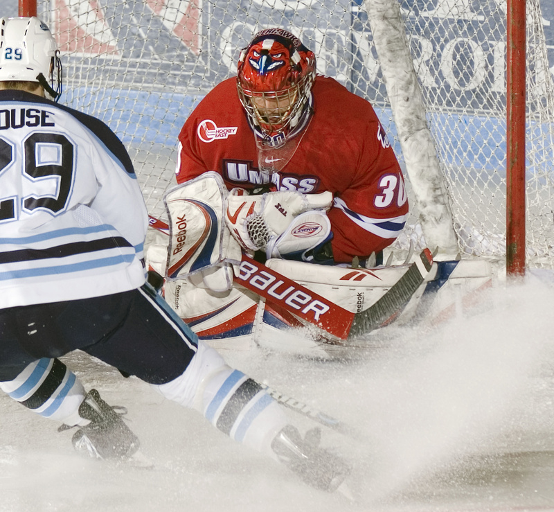 Lowell goalie Carter Hutton (30) cradles the puck in his glove after a shot by Maine's Tanner House (29) in the first period of an NCAA college hockey game Sunday, March 14, 2010, in Orono, Maine. (AP Photo/Michael C. York)