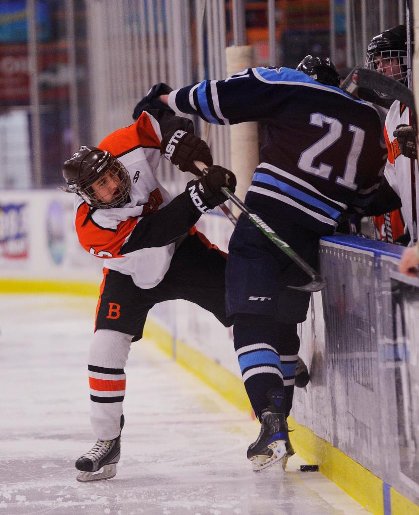 Michael Shedd of Brewer tries to take the puck from Paddy Murphy of York along the boards Saturday during the Class B state final at Lewiston. Brewer won, 3-1.