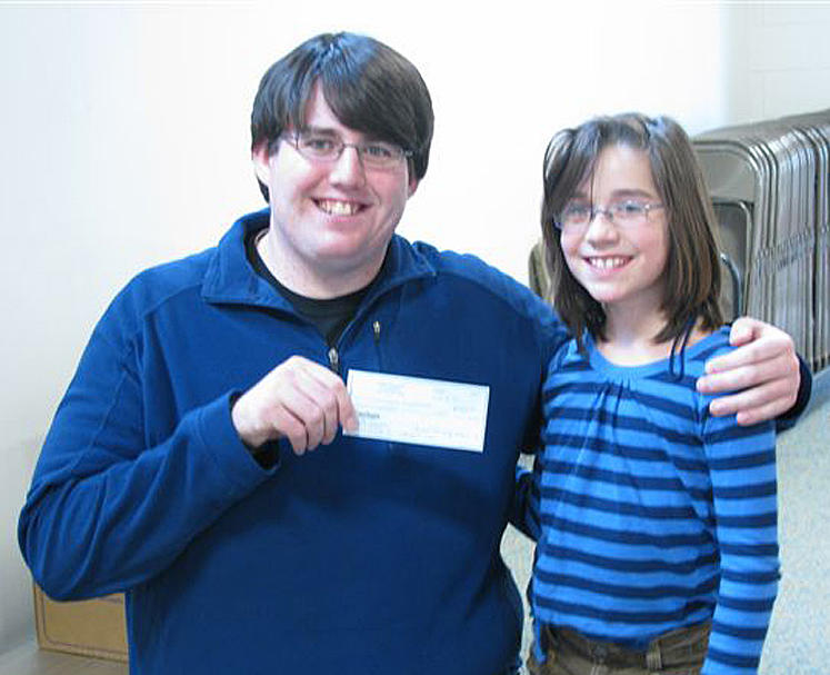 Michael Blais, left, of Standish, coordinator of Catherine’s Cupboard Food Pantry in Standish, receives a $500 check presented by Steep Falls Elementary School student Sydney Gillingham on behalf of the school’s Parent Teachers Organization.