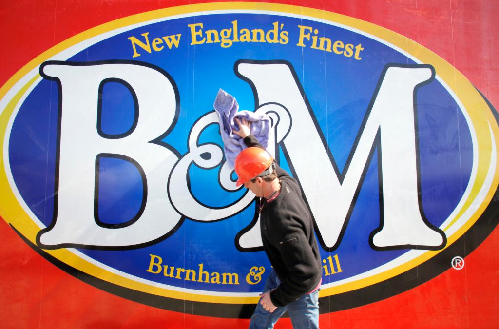 Kyle Noyes, with Sign One of Falmouth, wipes down the new B&M Baked Beans sign before it gets lifted into place at the top of the bean factory in Portland on Friday.