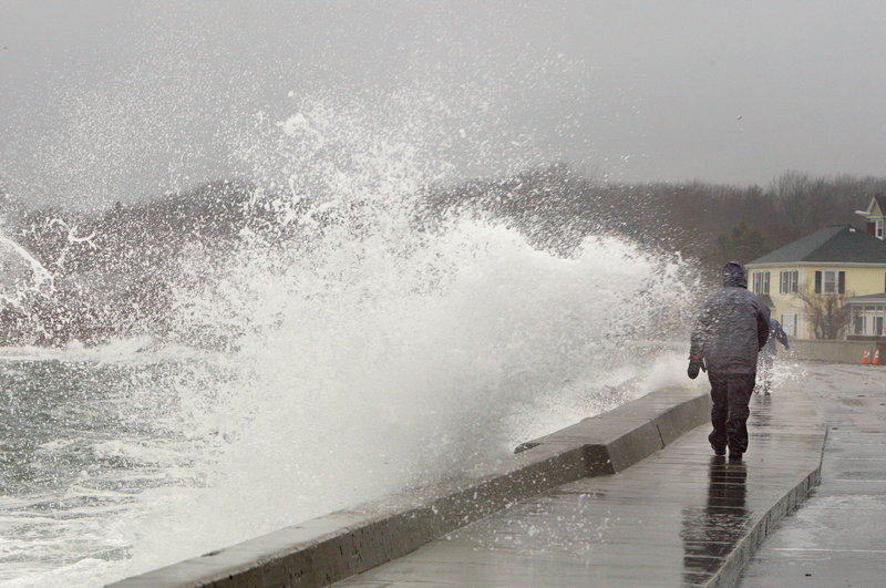 Bill Pasquill of Kennebunk walks along Beach Avenue in Kennebunk on Monday. The National Weather Service issued a coastal flood watch through Wednesday for parts of Maine. With more rain forecast for today, this month could end up being the wettest March on record.