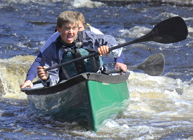 Christopher Deane and John Goulet muscle their way off a rock that they had hung up on while running the rapids in the St. George River Race in Searsmont, the first major canoe race of the year.