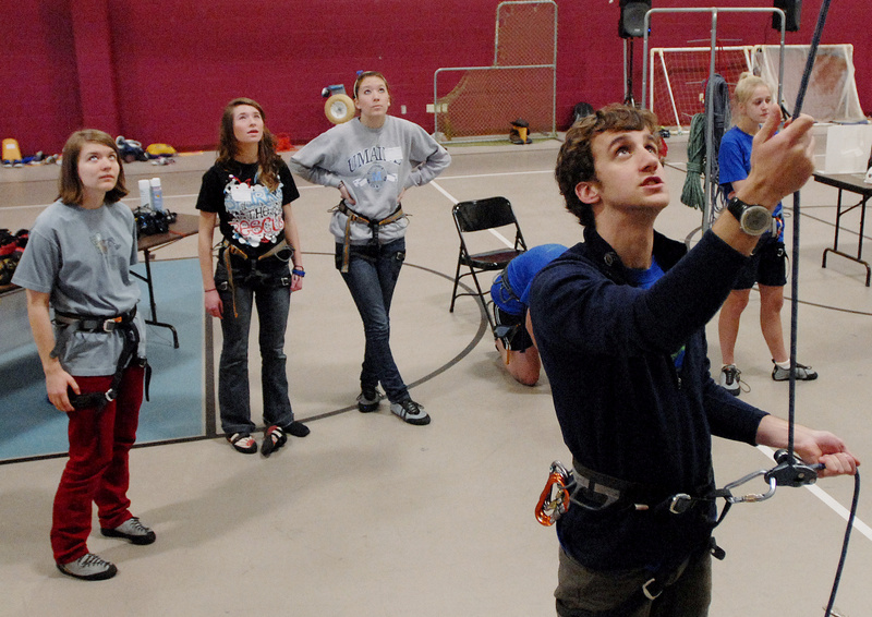 Wiley Muller, a teacher at Windham High School, guides a climber up the rock wall. The Leones hope to make the Teens to Trails conference a biennial event. And, Carol Leone says, “There are other things we want to do.”