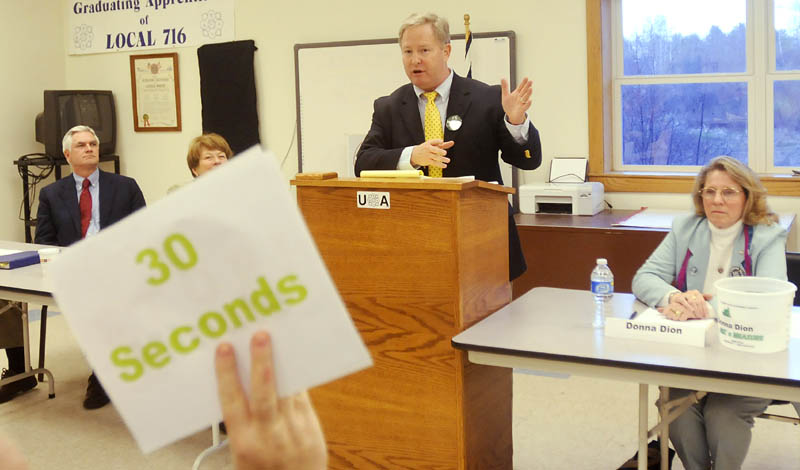 DEMOCRATS' DISCUSSION: Pat McGowan is warned with a sign that he has 30 seconds to finish speaking Thursday evening during a forum for Democratic candidates for governor held at Local 716, Plumbers and Pipefitters Union, in Augusta. Steven Rowe, left, Elizabeth Mitchell, and write-in candidate Donna Dion, right, attended the event.