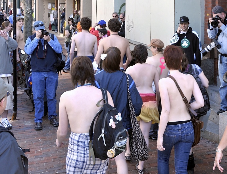 A group of women and men who had shed their tops march down a Congress Street sidewalk from Longfellow Square to Tommy's Park. They were promoting the freedom of women to be topless in public. The group attracted many amateur and professional photographers.