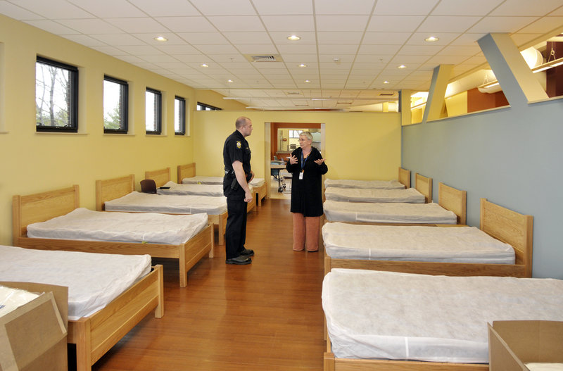 Terry Valente, a supervisor at Florence House, talks with Patrolman Chris Sibley during a tour by the Portland Police Department last week. They are in the emergency shelter part of the facility.