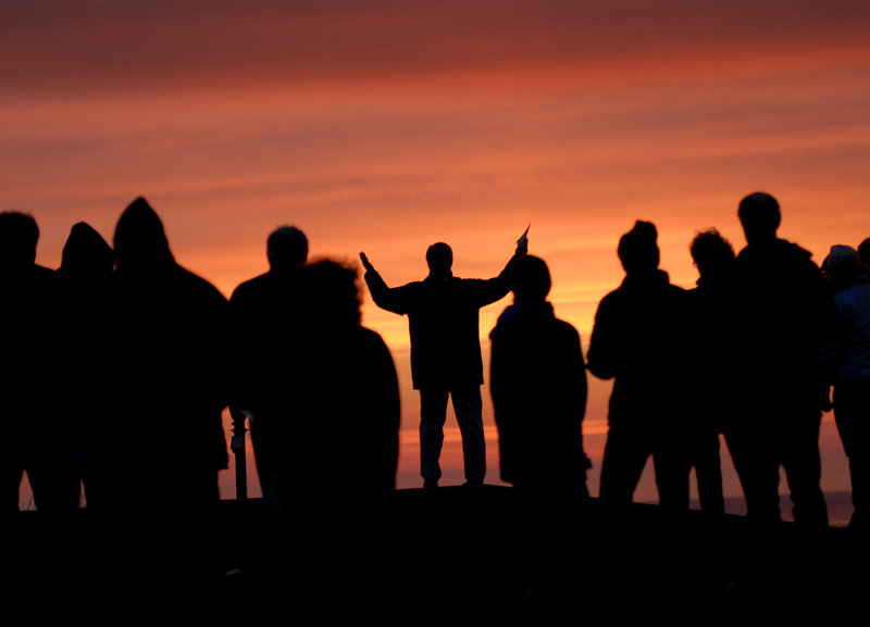 The Rev. John McCall, center, senior minister of First Congregational Church, United Church of Christ in South Portland, leads an Easter sunrise service at Fort Williams Park in Cape Elizabeth on Sunday.