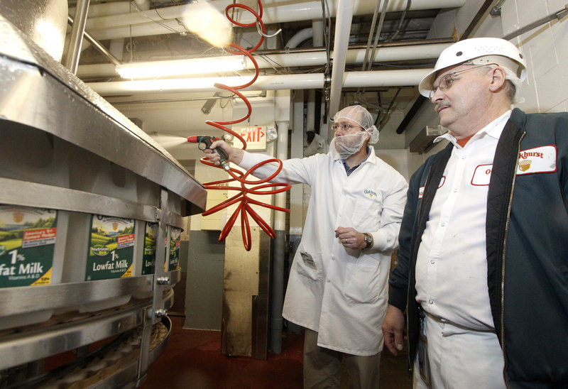 Reporter Ray Routhier, his face shrouded in a beard net, learns the duties of a filler operator at Oakhurst Dairy in Portland from Ronald Madore Jr. of Buxton.