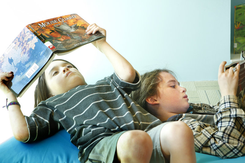 Ayden Grimm, 7, left, and his brother Elias, 9, read books in the new children's area during the grand reopening of the Portland Public Library on Thursday.