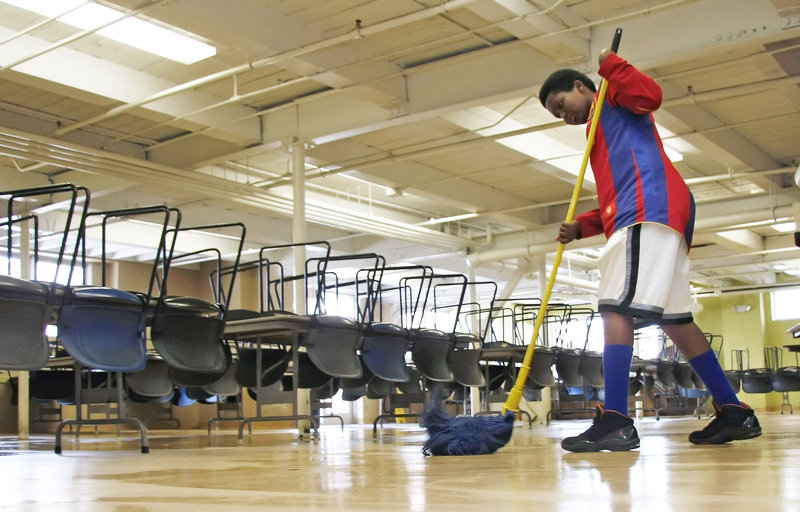 Sahal Hourdeh, a seventh-grader at Lincoln Middle School, mops the cafeteria floor as a student volunteer at Preble Street Resource Center. Students in the program will also go to Cow Island, to engage in gardening and environmental projects aimed at building leadership skills.