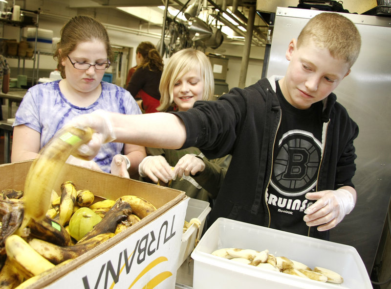 Sahal Hourdeh, a seventh-grader at Lincoln Middle School, mops the cafeteria floor as a student volunteer at Preble Street Resource Center. Students in the program will also go to Cow Island, to engage in gardening and environmental projects aimed at building leadership skills.