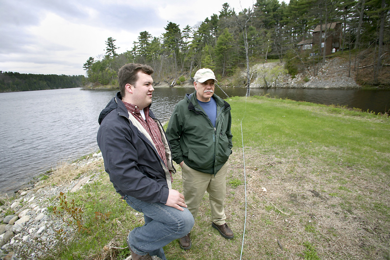 Ryan Tipping-Spitz, left, environmental organizer with the Maine People’s Alliance, and Tim Conmee, a resident of Orrington and MPA member, walk along the Penobscot River, where erosion has been a problem because, the DEP says, groundwater is leaking into five tainted landfills.