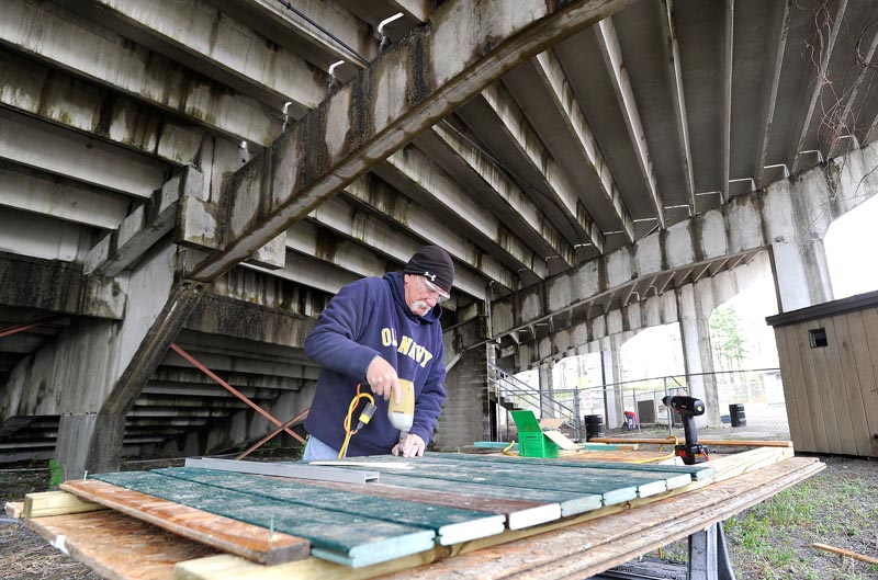 Jack Sarnow repairs fencing as he and other volunteers clean up The Ballpark.
