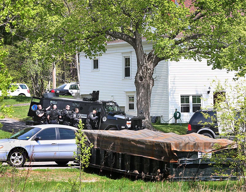 The Portland SWAT team approaches the rear entrance to an apartment during a police standoff on outer Forest Avenue in Portland on Sunday.