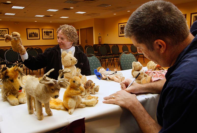 Willow Femmechild of Portland plays with one of her puppets Sunday while Bruce Zalkin estimates the value of her collection.