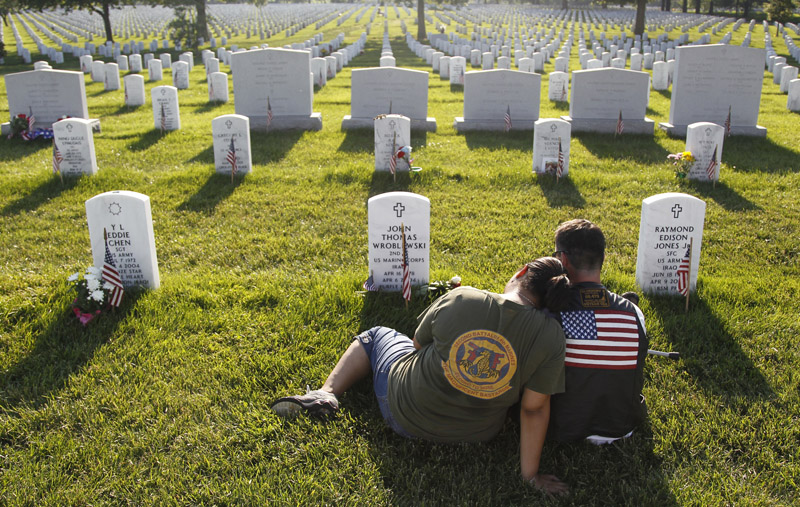 Marine Cpl. Patrick LeBlanc and his wife Kimberly of Greensboro, N.C., visit the gravesite of LeBlanc's platoon commander, Marine 2nd Lt. John Thomas Wroblewski Sunday at Arlington National Cemetery.