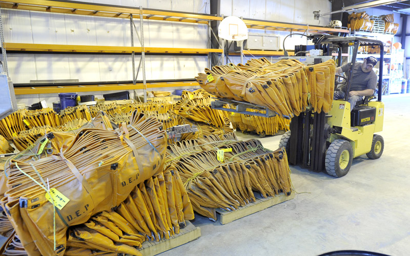 Chris Estes, a forklift operator for the Department of Environmental Protection, loads containment boom from a Portland warehouse onto a waiting tractor-trailer to be delivered to Louisiana.