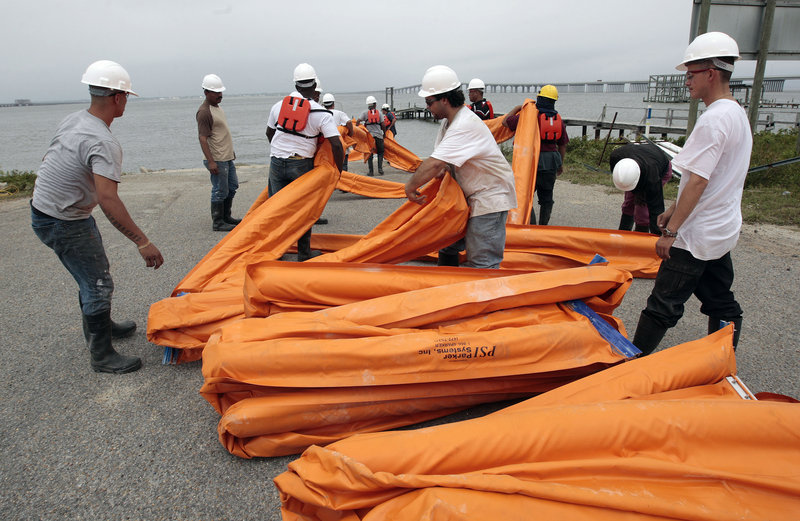 Workers spread oil booms along a railroad trestle that crosses the bay in Bay St. Louis, Miss., as preparations continued Friday to head off impending damage from a massive oil spill along the Gulf Coast.