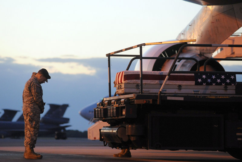 A transfer case containing the remains of Spc. Wade A. Slack sits on a loader during a prayer Saturday at Dover AFB, Del. Slack, 21, of Waterville, died Thursday in Jaghatu, Afghanistan, according to the Department of Defense.