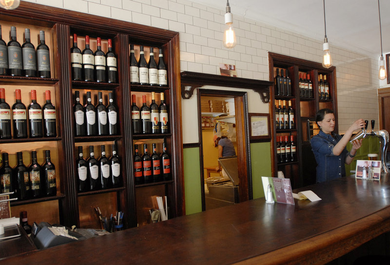 Bartender Rebeca Collado pours a beer at Enzo Pizzeria in Portland. In addition to the classic Margherita, popular pies include mashed potato pizza with bacon and scallions, and butternut squash pizza with ricotta and cranberries.