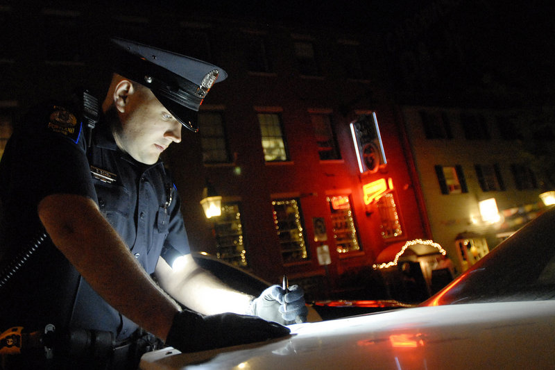 Portland Police Officer Evan Bomba fills out an inventory report after he and Officer Vincent Rozzi arrested a suspect on an OUI charge and ordered his car towed. The officers were patrolling the Old Port entertainment district Friday night.