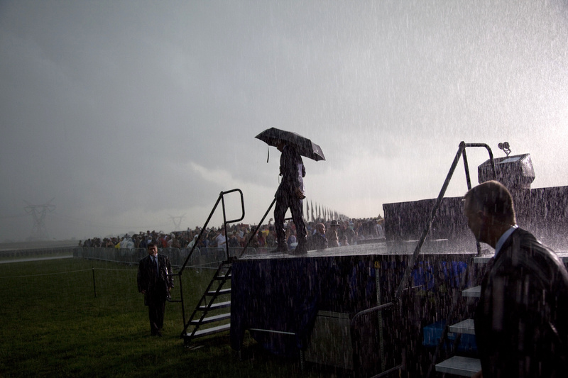 President Obama walks off stage in the rain after urging people to go to their cars during a Memorial Day ceremony at Abraham Lincoln National Cemetery in Elwood, Ill. He later spoke to troops at Andrews Air Force Base outside Washington.