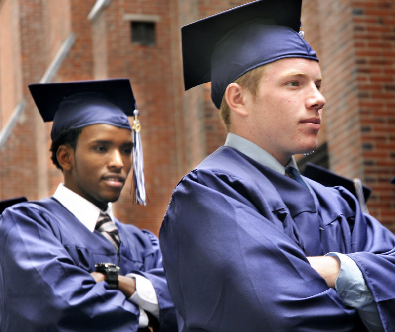 Portland High School seniors Yussuf Ali, left, and Kevin Nielsen wait to enter Merrill Auditorium in Portland for their graduation ceremony on Wednesday.