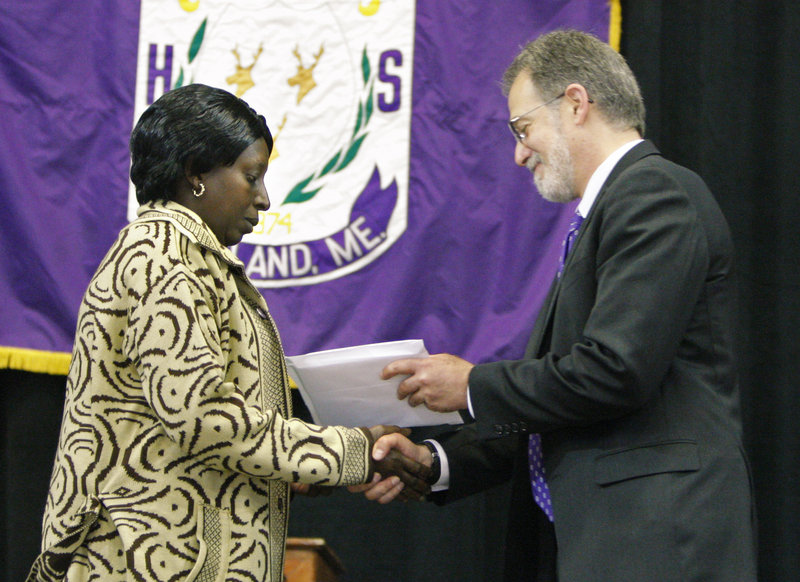 Synforose Rugema receives a diploma on behalf of her son Guy Kitoko, who was killed in a car accident last September.