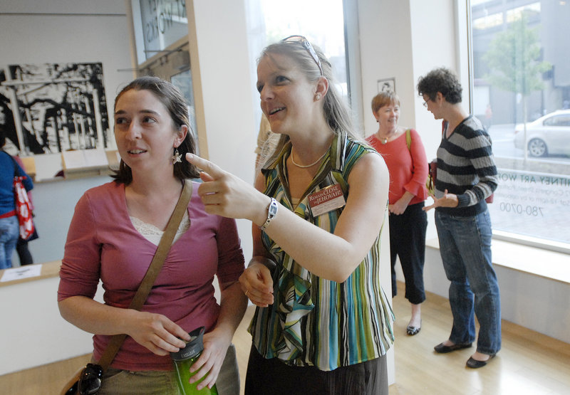 Yvonne Stevens of Portland and Heather Broersma of Westbrook check out the art on display at Whitney Art Works during the art walk in Portland.