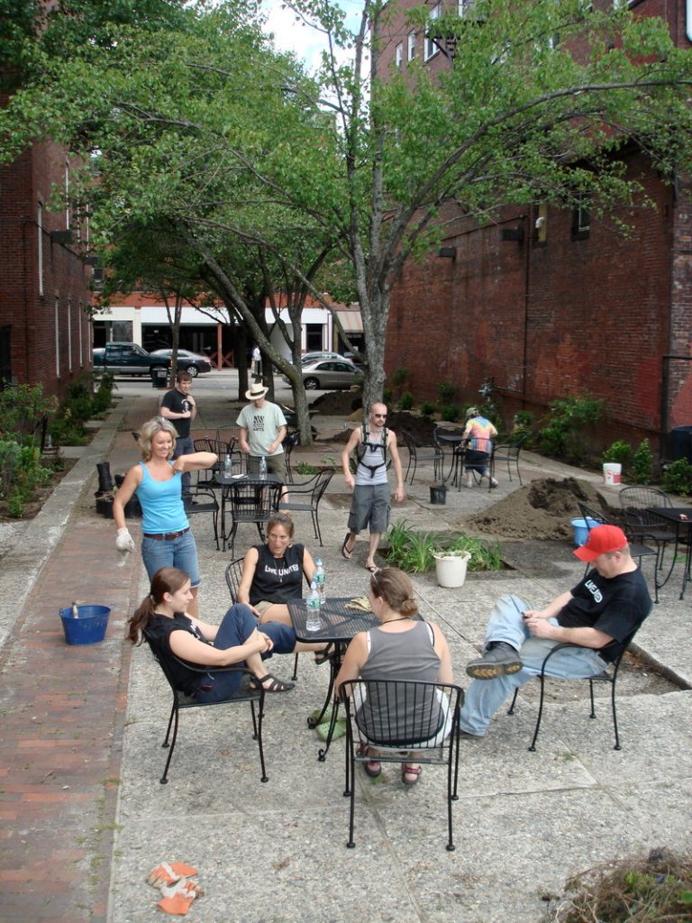 Holli Andrews, left, takes a moment away from working on the Shevenell Park gardens to talk with some people enjoying the area.