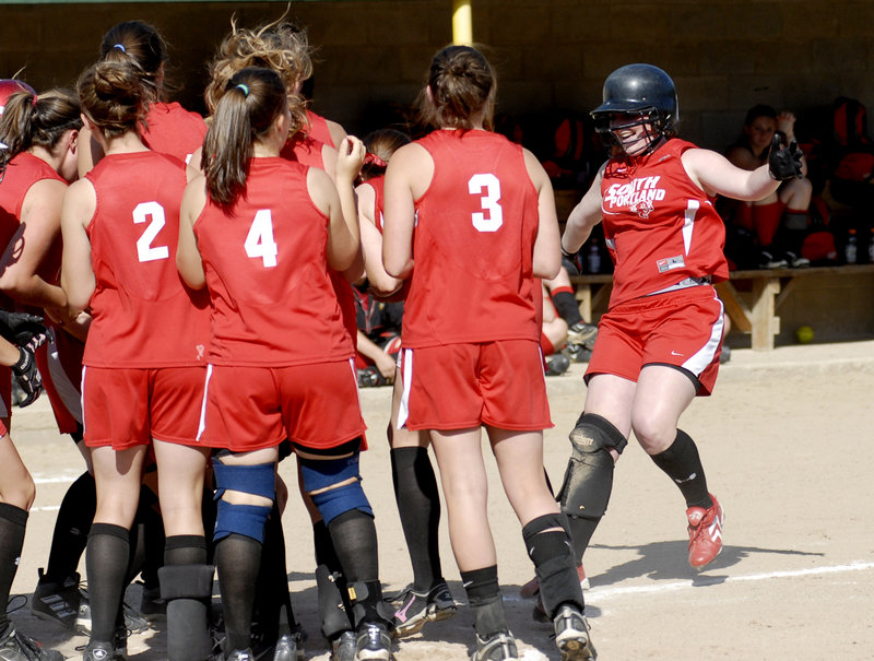 Katlin Norton makes sure she touches home plate before getting congratulations from her South Portland teammates after hitting a three-run home run that broke a 1-1 tie in the fifth inning and helped the Red Riots beat Scarborough 5-2.