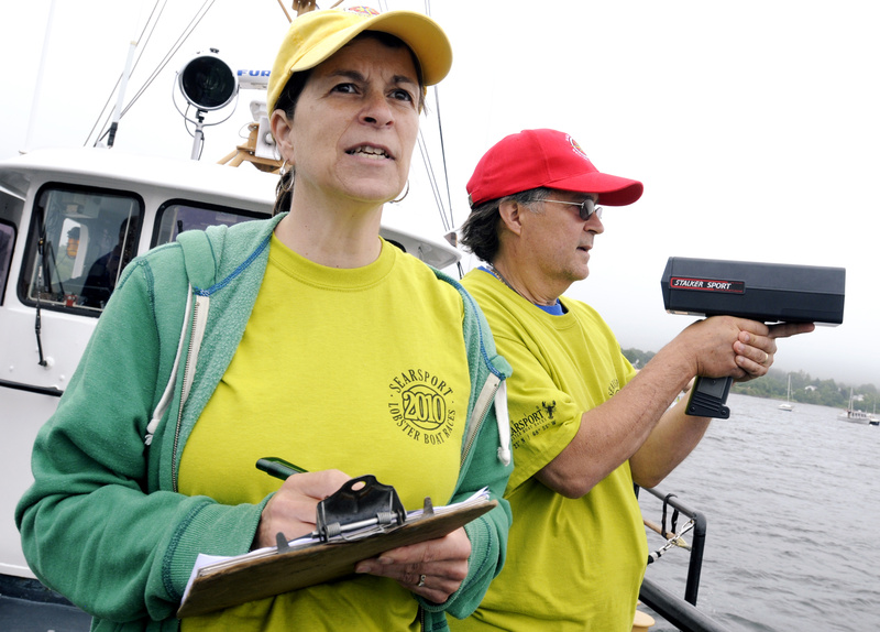 Race officials Patty and Jim LeClair watch from the Coast Guard boat as racers cross the finish line. The family owns and operates the Maine Coast Welcome Center in Belfast.