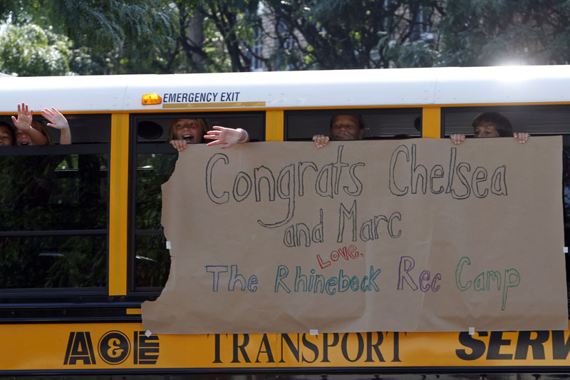 Children wave at members of the media from a bus decorated with a sign congratulating Chelsea Clinton and Marc Mezvinsky today in Rhinebeck, N.Y.