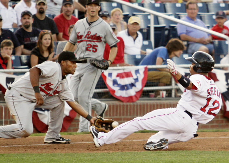 Matt Sheely of the Sea Dogs beats a throw to New Britain third baseman Juan Portes and slides in for a triple during the fourth inning of Portland’s 7-5 victory Friday night at Hadlock Field. Sheely later scored after drawing an errant throw.