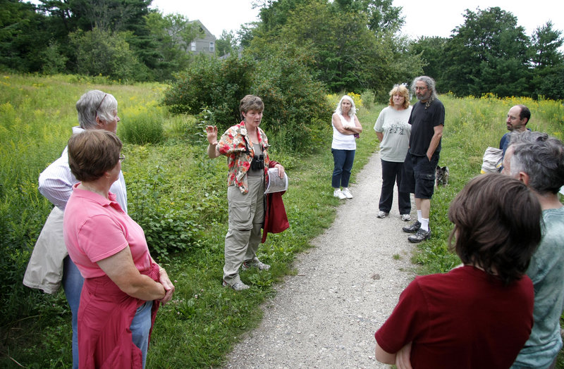 Portland Trails advisory board member Lois Winter leads a tour of Portland’s Capisic Park on Friday, explaining a plan to rip up the trail as part of a sewer line upgrade. City workers are preparing to replace and separate sewers that send untreated sewage into Casco Bay during heavy rains.