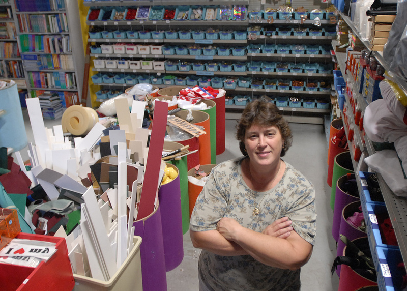 Ruth Libby of Ruth’s Reusable Resources stands surrounded by stocked shelves in her public store, where she will sell surplus items or supplies that teachers don’t need.