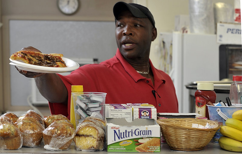 Milton Hammith, the cook at the Clock Tower Cafe, serves up a slice of pizza to a regular customer.