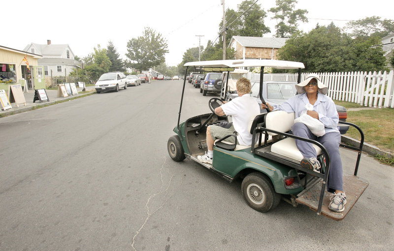 Matt Rand gives a ride to Meikie Jenness on Peaks Island on Thursday. Rand offers rides for free and makes money from tips. Some people are concerned because Rand is taking business away from the island's struggling taxi service, which operates year round and is subsidized by the city of Portland.