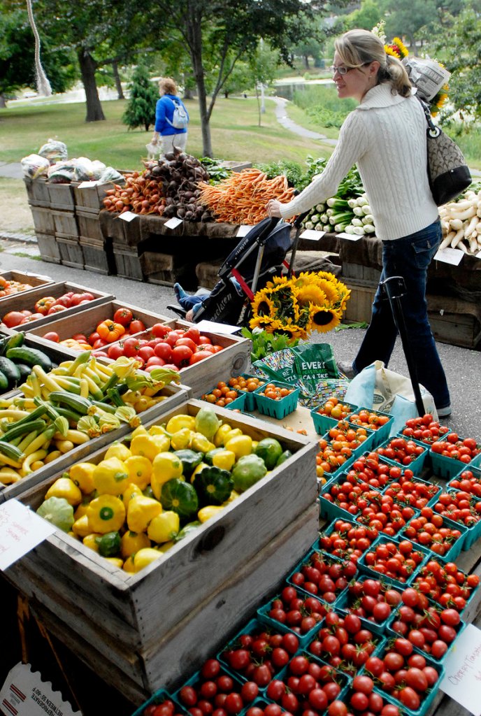 Rebecca Ermlich looks over the produce at Freedom Farm’s display at the farmers market at Deering Oaks recently.