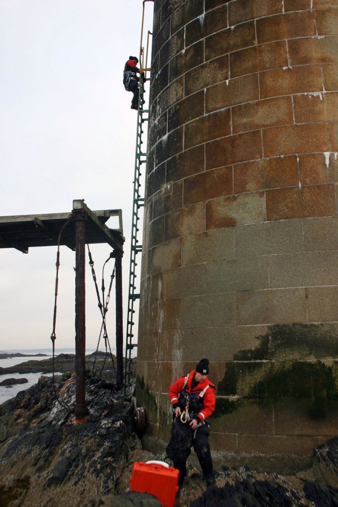 To get inside the 105-year-old Ram Island Ledge lighthouse, Coast Guard technicians have to climb a 30-foot exterior ladder.