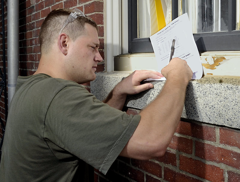 Kyle Crooker, an employee of Maine Day Labor, signs his time sheet before going home for the day. Some of the workers participated in a program at the Maine Correctional Center entailing 60 hours of training in such areas as demonstrating responsibility, problem solving, honesty and interview skills.