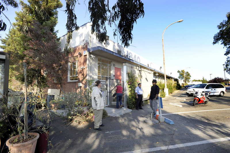 Security personnel stand outside as a patient enters Harborside Health Center in Oakland, Calif. The city limits its number of dispensaries and regulates them closely.